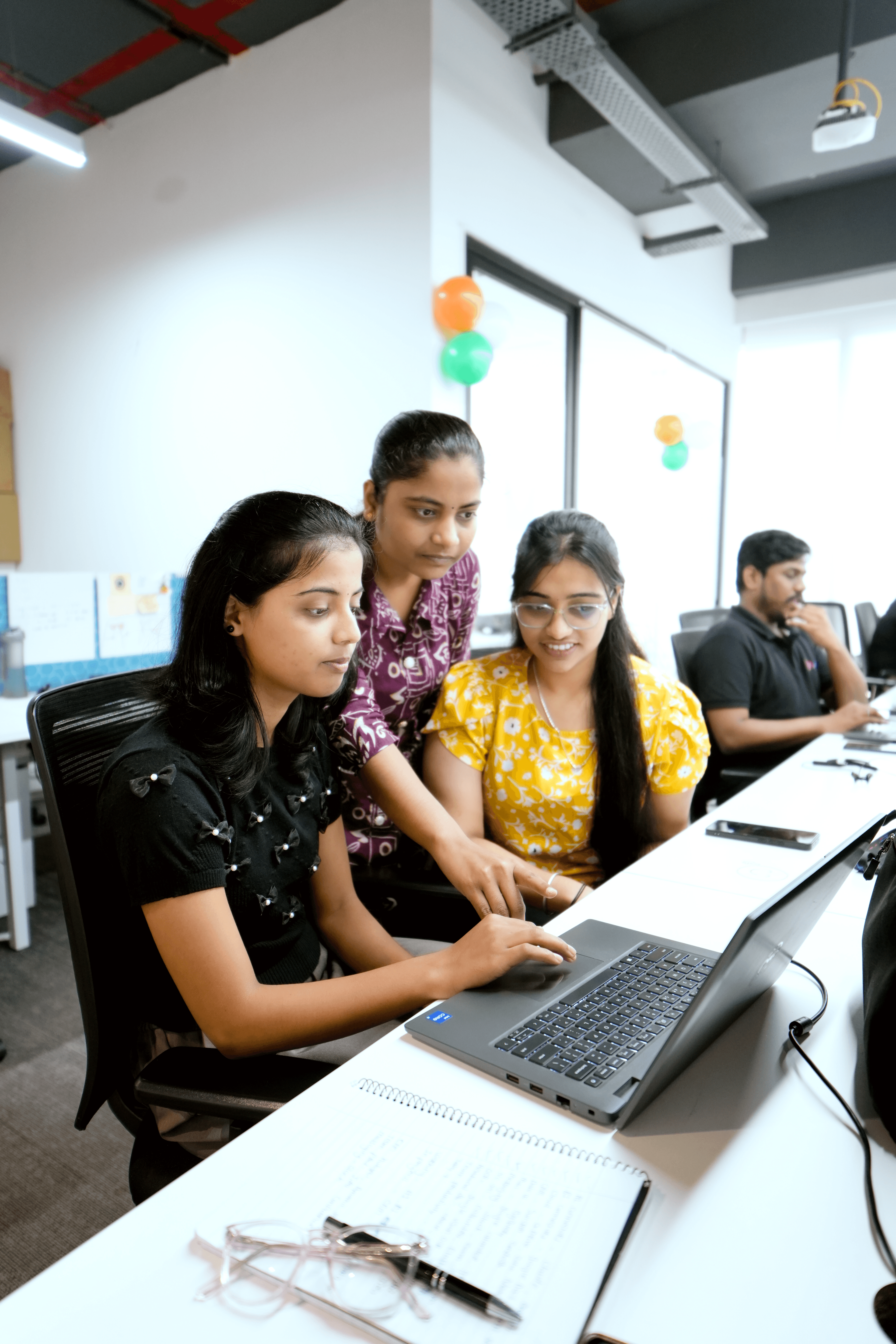 Yukosa team members reviewing workflow diagrams together at a multi-monitor workstation